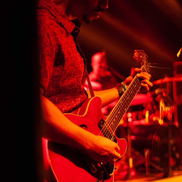 Man_standing_playing_a_guitar.jpg